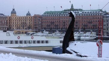 Stromkajen kamienice statki wycieczkowe nabrzeże Sztokholmu atrakcje zima śnieg Szwecja łódź Wikingów