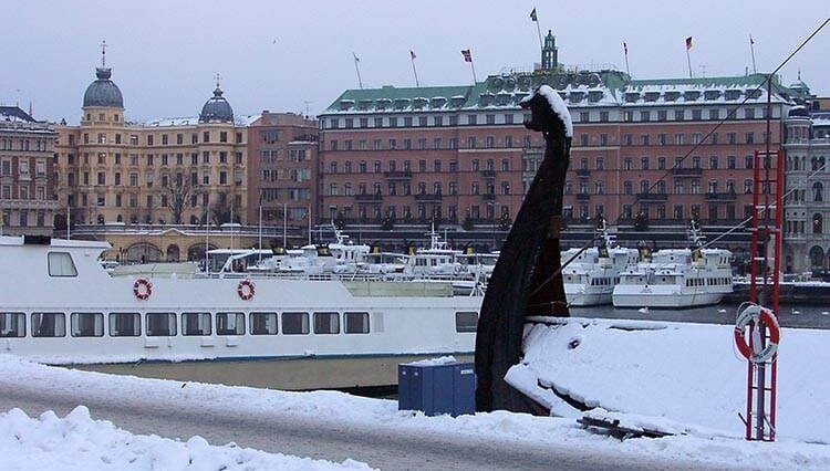 Stromkajen kamienice statki wycieczkowe nabrzeże Sztokholmu atrakcje zima śnieg Szwecja łódź Wikingów